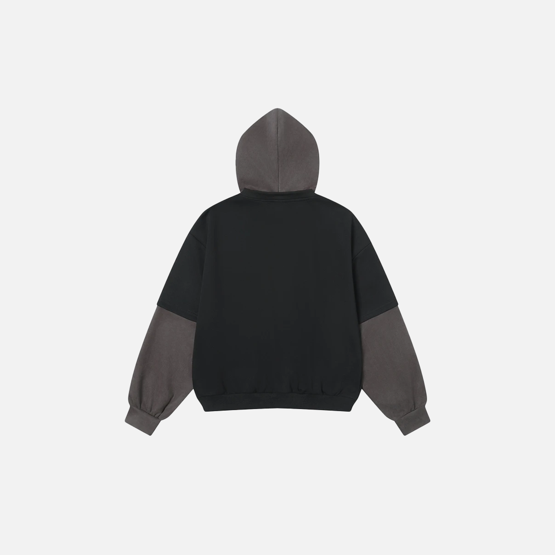 Front view of model wearing black fake two-piece hoodie with white letter print and grey layered sleeves